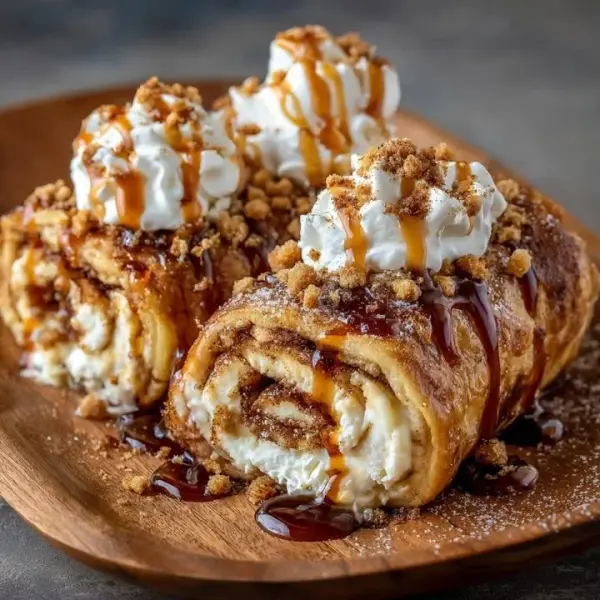 Cinnamon Roll Cheesecake Chimichangas served on a plate with cinnamon drizzle.