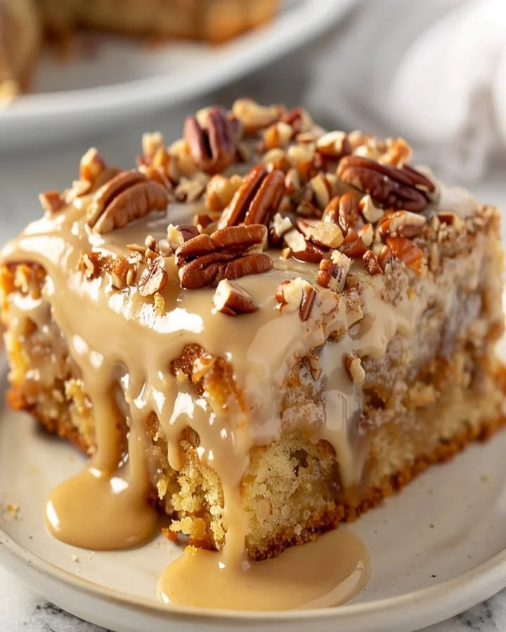Delicious Butter Pecan Praline Poke Cake garnished with pecans and praline topping.