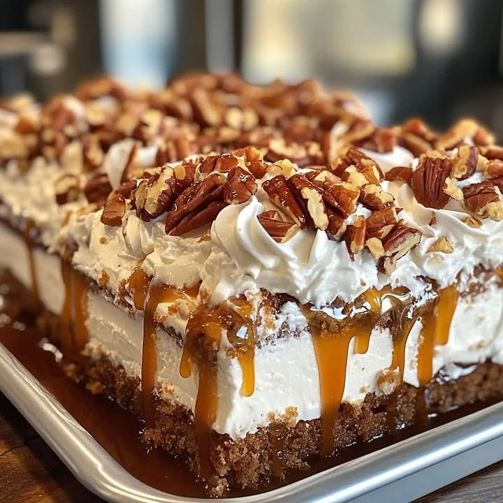 Butter Pecan Praline Poke Cake topped with pecans and caramel sauce