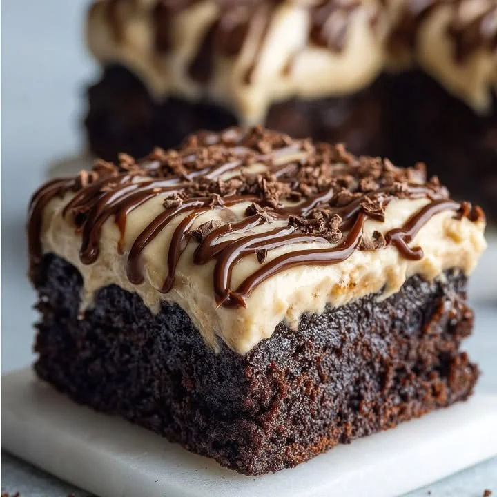 Delicious Irish Cream Chocolate Brownies topped with creamy frosting and chocolate drizzle