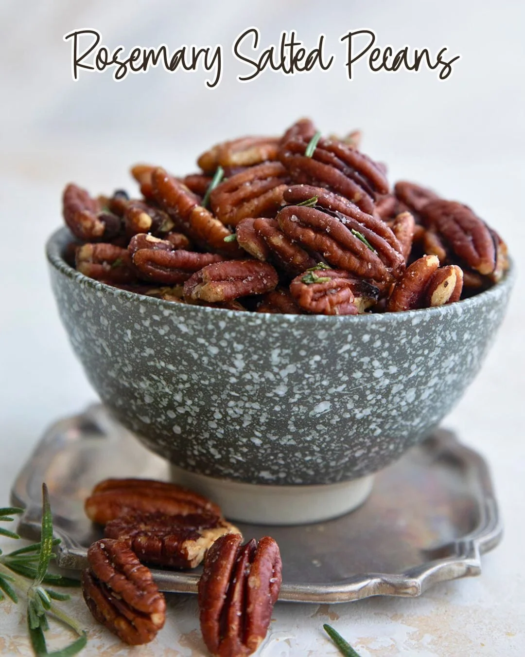 Bowl of salted rosemary pecans, a savory and flavorful snack.