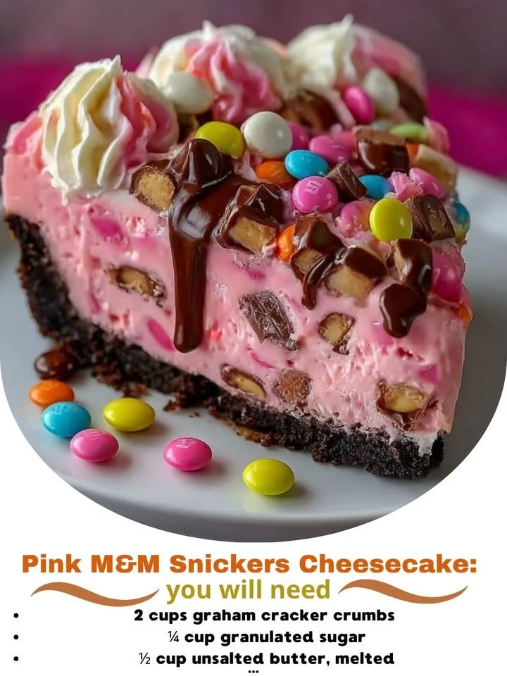 Slice of Pink M&M Snickers Cheesecake garnished with colorful candies