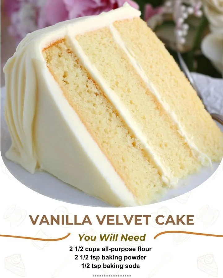 A slice of Vanilla Velvet Cake topped with creamy frosting and fresh berries