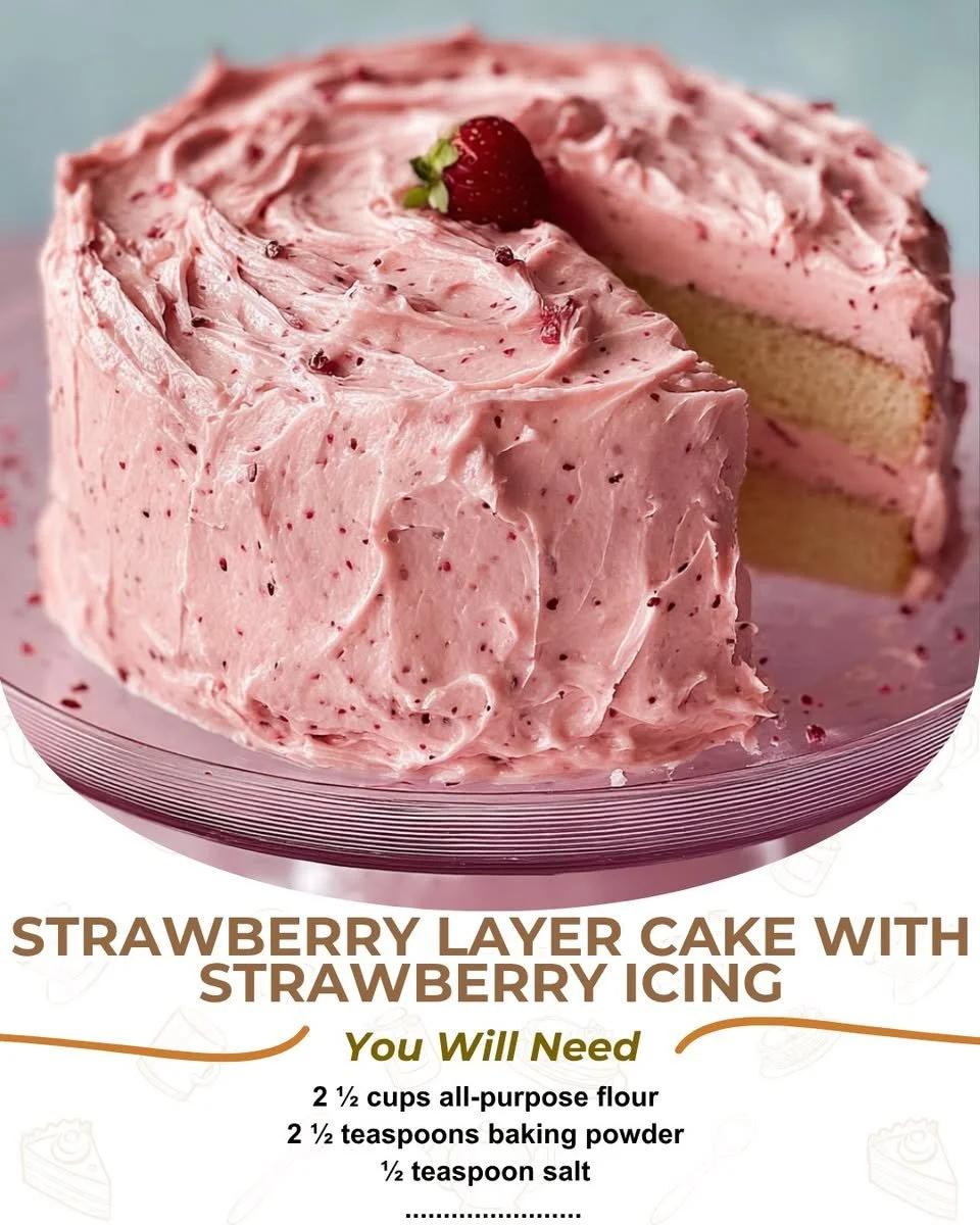 Delicious strawberry layer cake topped with creamy icing and fresh strawberries