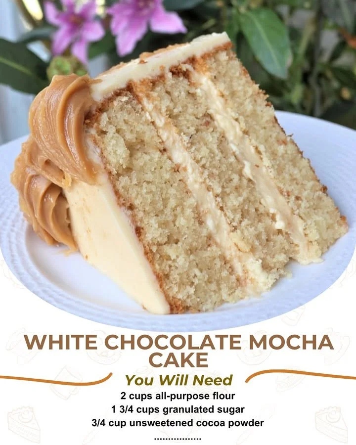 Delicious slice of White Chocolate Mocha Cake topped with cocoa and white chocolate shavings